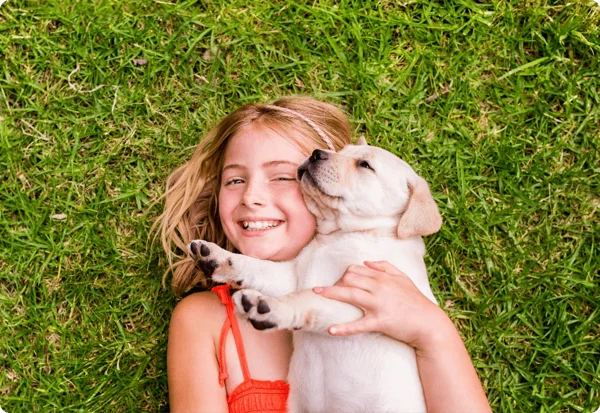 child and puppy on grass