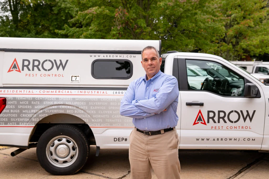ArrowPestControl person standing in front of truck