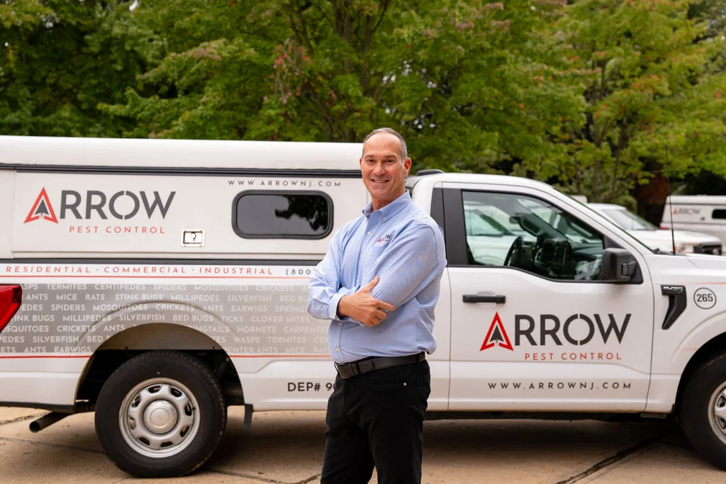 ArrowPestControl person standing in front of truck